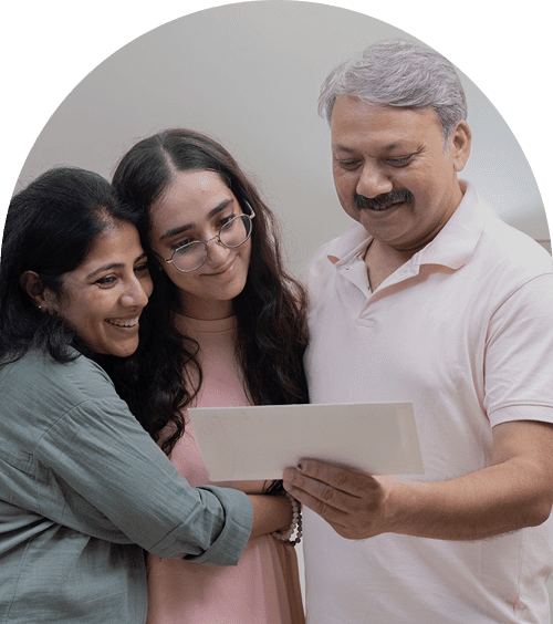 Family smiling and looking at a document.