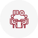 Two people talking at a table icon.