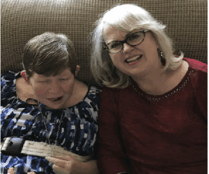 A joyful moment between two women sharing a laugh and a book.